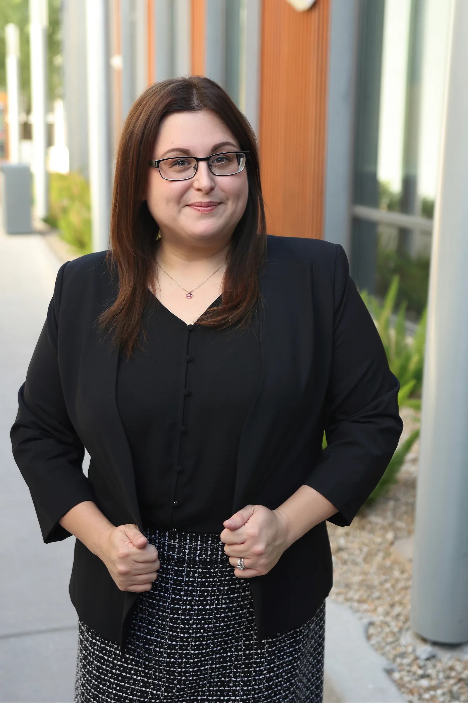 Jaclyn Kliewer, partner at Summit Trial Attorneys, in a black blazer and glasses outdoors