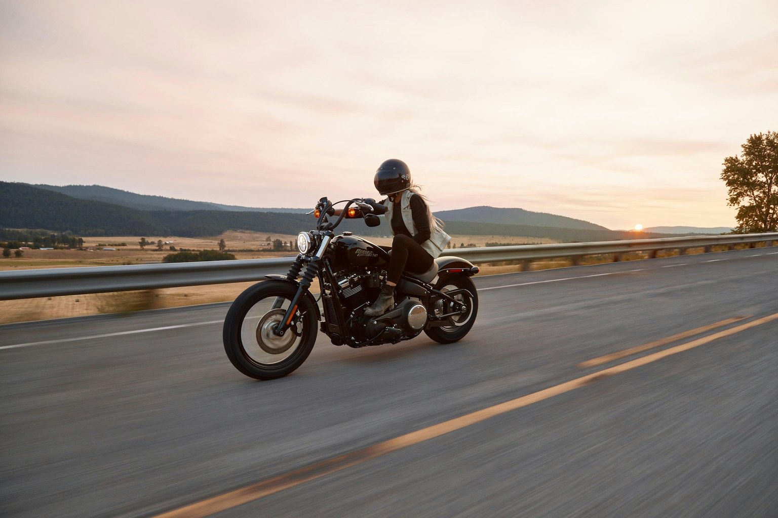 Rider on a black motorcycle traveling a highway at sunset, a scene a Las Vegas motorcycle accident lawyer may review after a crash