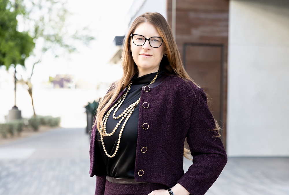 Renee M. Finch, founding partner at Summit Trial Attorneys, in a burgundy jacket and glasses outdoors