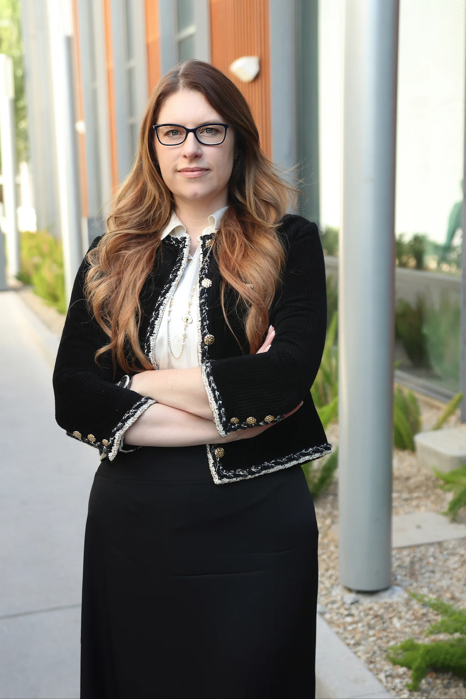 Renee M. Finch, founding partner at Summit Trial Attorneys, in a black jacket with braided trim and glasses outdoors